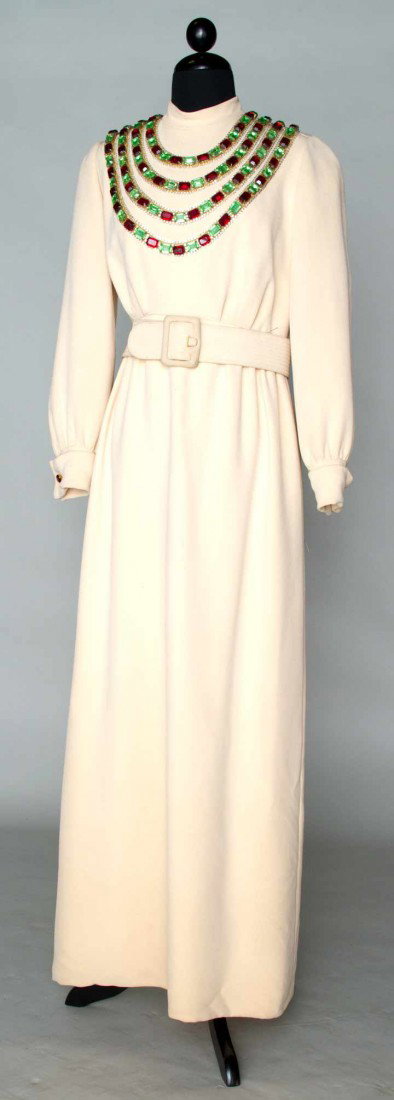 NORMAN NORELL EVENING GOWN, 1968: Bone silk crepe gown, mock turtle neck, long cuffed sleeves, bodice w/ 4 row large jewel swags in red & green, wide top-stitched crepe belt, B 36", W 28", L 56" ( 1 green jewel missing in CB, light di