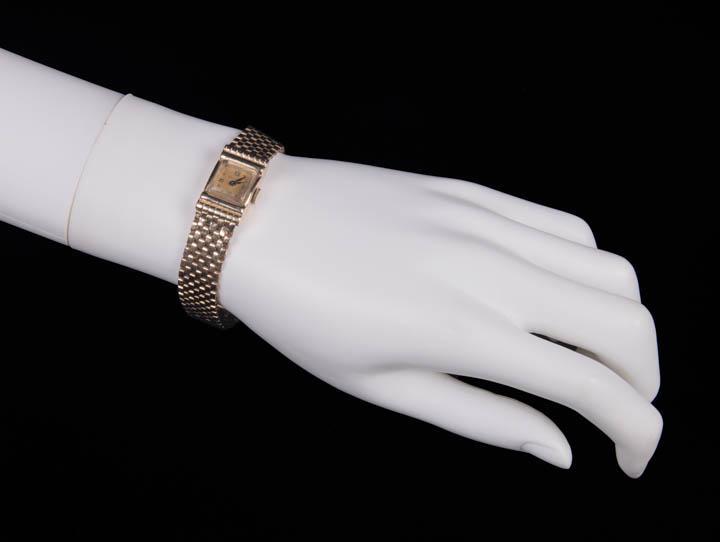 14K BULOVA TANK WATCH & BAND: Ladyâ€™s quartz tank watch w/ â€œBulova” on face & 14k yellow gold band, laid flat 0.5" x 7.25”, weighing 21.15 dwt including movement & case, (light scratches, minor tarnish to d