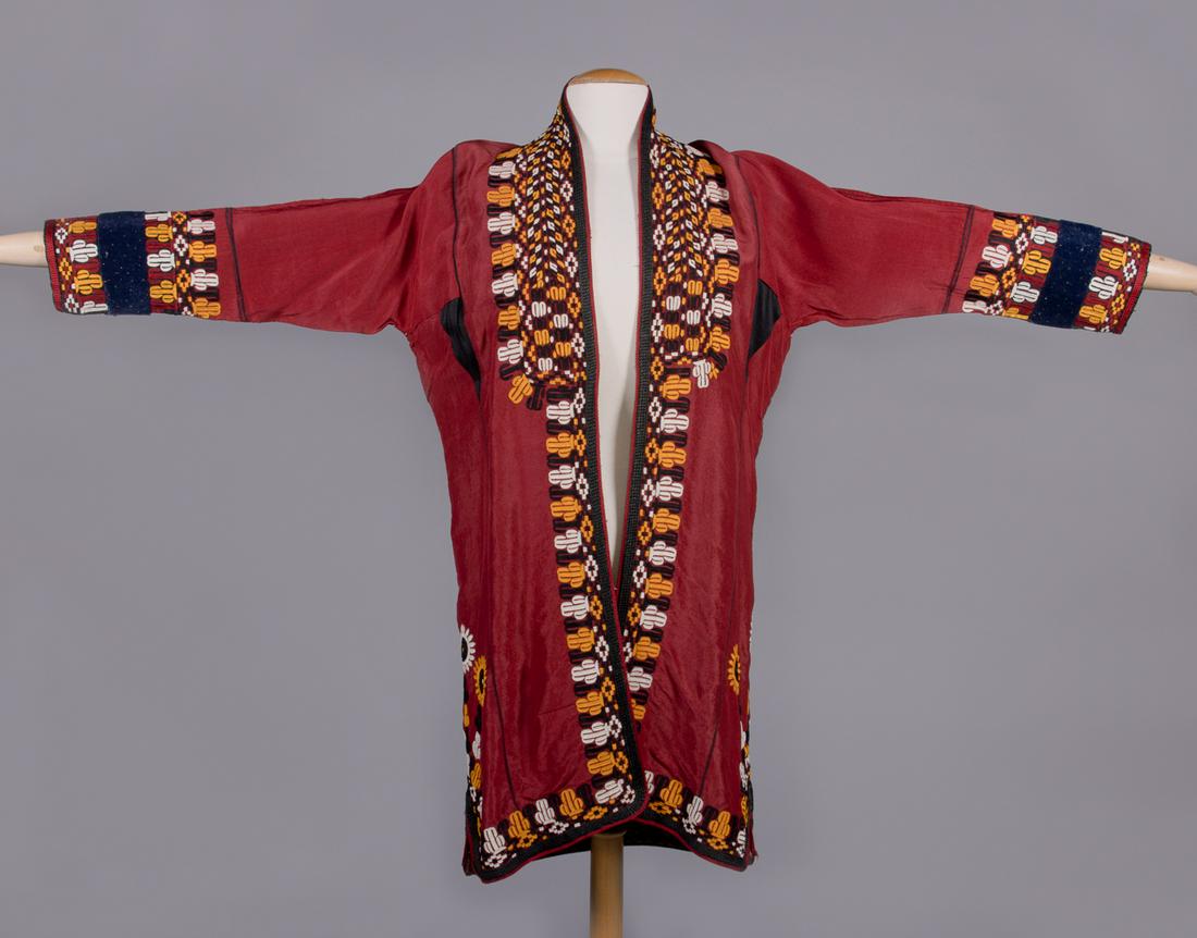 WOMANS CHYRPY, TURKMENISTAN, 1940-1950s: Red silk w/ woven borders & elaborate hand embroidery to neckline, CF opening, cuffs & hem, flocked velvet bands applied to cuffs, lined in printed cotton, Tekke people Turkmenistan, CH 42", L 37", (f