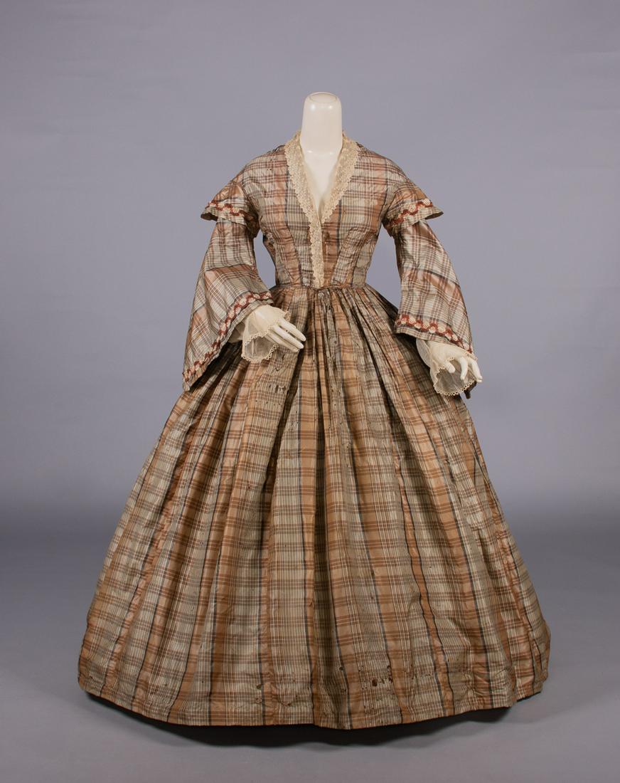 PLAID SILK DAY DRESS, MID 1850s: Silk taffeta one piece day dress w/ chemical lace collar, woven silk trim w/ loops, SH caps over pagoda sleeves w/ engageante under sleeves of cotton tulle edge w/ tatting, piped armscye & W, complex 