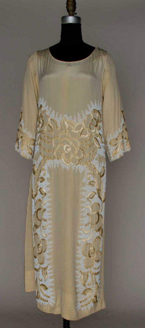 BEADED CREAM SILK EVENING GOWN, c.1922: Fine silk cream faile, sleeveless gown, silk underdress w/ attached elbow length sleeves, heavy beige silk floss embroidery on white chalk beading, B 32" W 26" L 48" (underarms badly stained, quarter