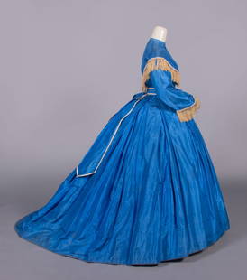 SAPPHIRE BLUE SILK TAFFETA DAY DRESS, MID 1860s: Sapphire blue silk taffeta w/ high round neckline, carved MOP CF buttons, cream & straw colored tasseled braid to yoke & above cuff of shaped military 2-pc sleeve, very full trained box pleated skirt