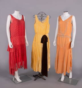 THREE SILK CREPE OR VELVET PARTY DRESSES, 1922-1928: 1 tomato red silk crepe chiffon w/ short garnet colored bugle beads in arrowhead pattern, scoop neckline, horizontal drop W w/ gathered double panel at left H, hanging skirt panels ruched to drop W,