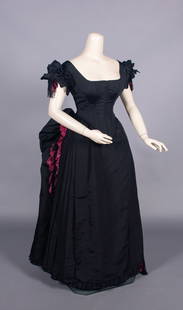 SILK FAILLE EVENING DRESS, c. 1884: 2-pc black silk faille evening gown c/o CF & CB lacing bodice w/ piped broad square neckline into V at CB, double puff sleeves & V waistline, fuchsia lace & passementerie tassel trim w/ black wooden