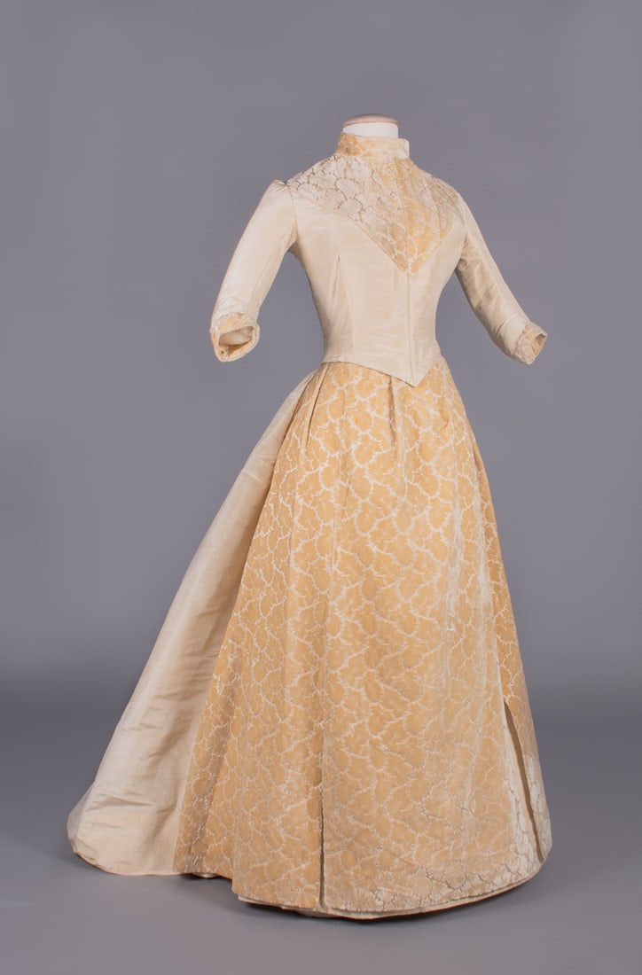 VELVET & MOIRE' COLONIAL REVIVAL DRESS, LATE 1880s: 2-pc cream silk moire’ w/ band collar, front yoke, cuffs & skirt in leaf motif patterned velvet gown, fitted back lacing bodice w/ elbow length sleeve, skirt w/ moire' trained back panel, B 30&rdquo