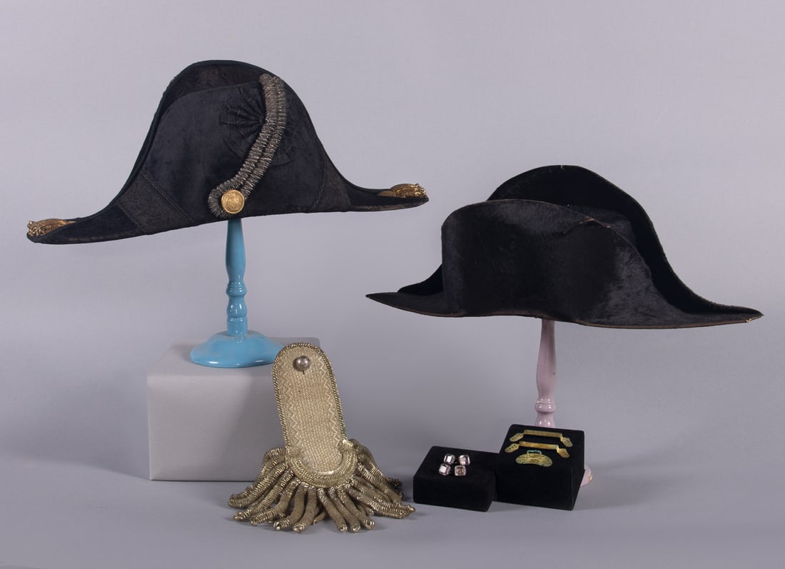 TWO BICORNE HATS & SINGLE EPAULET, BOSTON & LONDON, 1860s: 1 black silk bicorn hat w/ paper interior, label “S. Mason Jr. Boston”, L 17”, Wd 6.5”, Ht 6”, (plume missing, wear, pile loss, sweatband damaged); 1 black brushed silk velve