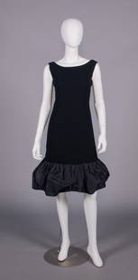 DIOR NEW YORK COCKTAIL DRESS, 1960s: 1 black wool crepe w/ bateau neckline, silk taffeta rose at CB into double ruffle continuing into broad puffed hem, label “Christian Dior-New York Inc.” & “Stuarts Boston, Mass”, B 36&