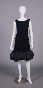 DIOR NEW YORK COCKTAIL DRESS, 1960s: 1 black wool crepe w/ bateau neckline, silk taffeta rose at CB into double ruffle continuing into broad puffed hem, label “Christian Dior-New York Inc.” & “Stuarts Boston, Mass”, B