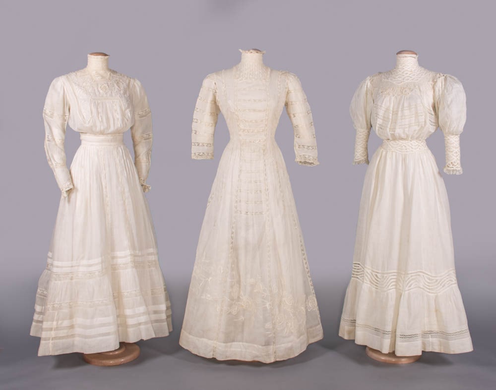 THREE COTTON BATISTE LINGERIE DRESSES, 1907-1909: 1 w/ machine lace insertions & Schiffli embroidered yoke, standing lace collar, long fitted sleeve, CB MOP button closure, c. 1907, B 36”, W 24”, L 56”, (0.5” holes front right