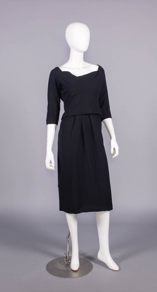 DIOR LABELED WOOL CREPE DAY DRESS, 1960s: Black wool crepe dress w/ scoop neckline, glove length sleeves, decorative self covered buttons to below right B, attached skirt pleated into waistband under faux peplum & back cummerbund w/ floating 
