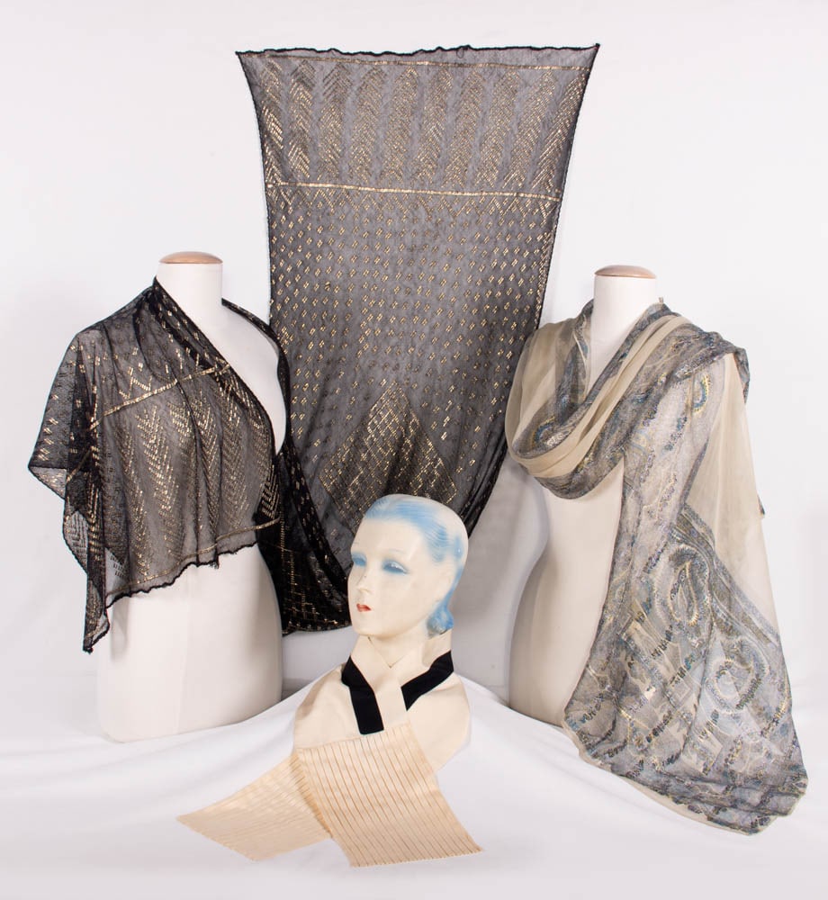 ASSUITE, BROCADED CHIFFON OR SILK CREPE SHAWLS, 1910-1920s: 1 black & silver Assuite shawl, 22.25” x 91.5”, (scattered minor pulls, some loose stitching at hem); 1 brocaded & overprinted silk chiffon scarf w/ paisley-inspired motifs, 22” x 94
