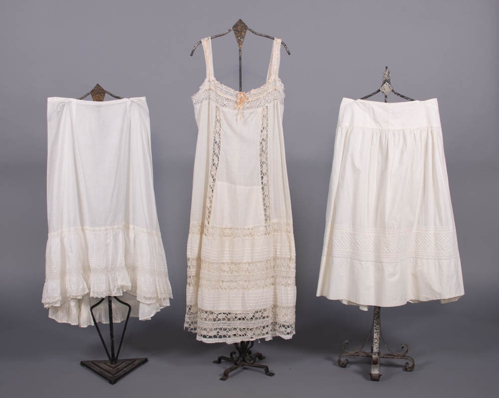 TWO PETTICOATS & ONE CHEMISE, LATE 19TH-EARLY 20TH C: 2 white cotton petticoats: 1 w/ horizontal & diagonal tucking & 1 w/ tucking & mm lace insertions; 1 chemise w/ faux bobbin lace insertions, all excellent. Measurements & condition report available up