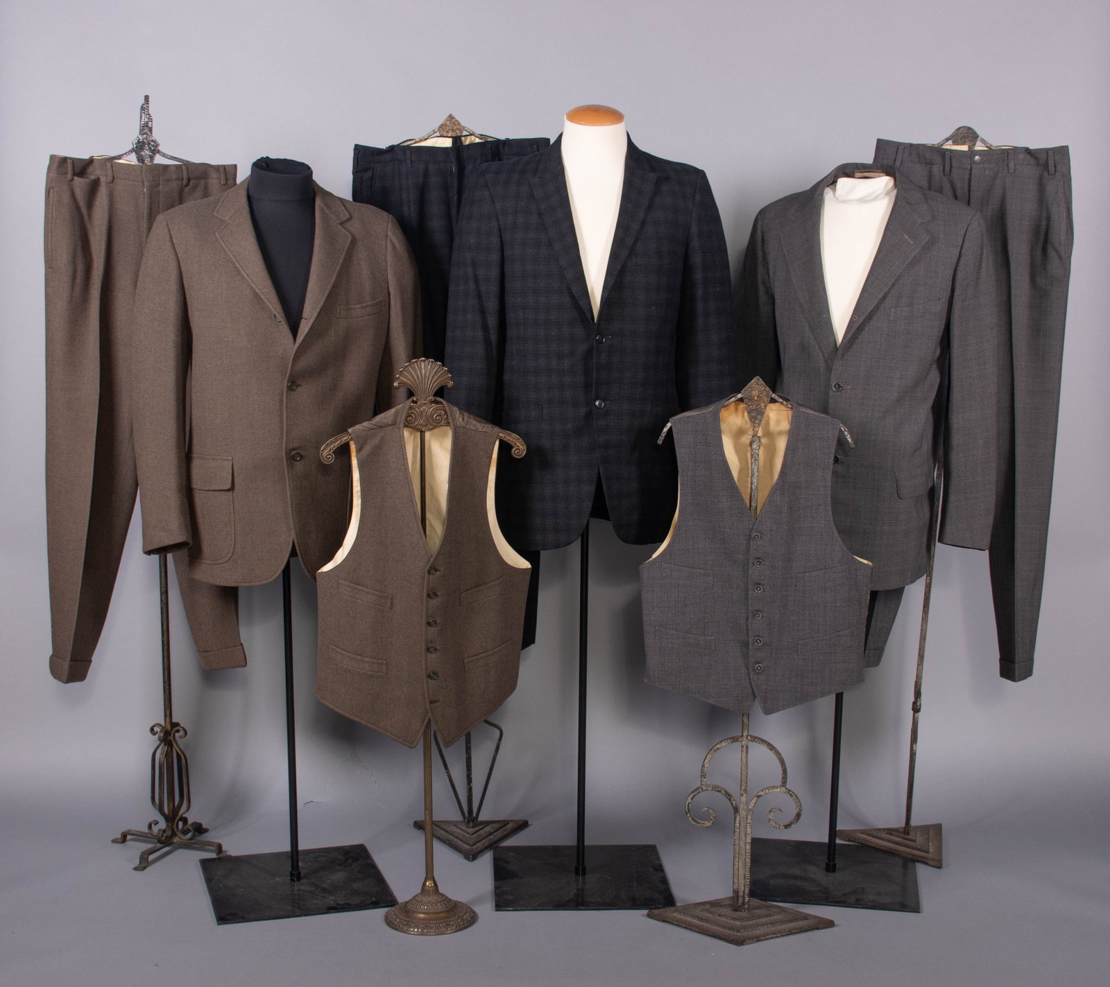 COLLECTION OF MEN'S SUITS, USA, 1954-1959: 3-pc suit of grey & tan herringbone wool, four-pocket waistcoat, jacket half-lined, label “Brooks Brothers” size 40, 1958; 2-pc suit of black and grey checkered wool, lined w/ black rayon, lab