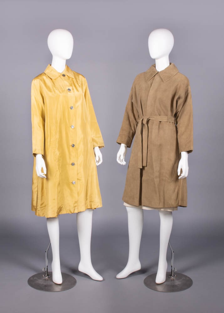 SCHIAPARELLI & BONNIE CASHIN COATS, PARIS & USA, 1950s & 1970s: 1 mustard silk spring/summer coat w/ CF button closures, front H pockets & draped inverted-V panel over back SHs, label "Schiaparelli Paris"; 1 brown suede trench coat w/ free front & original belt, l