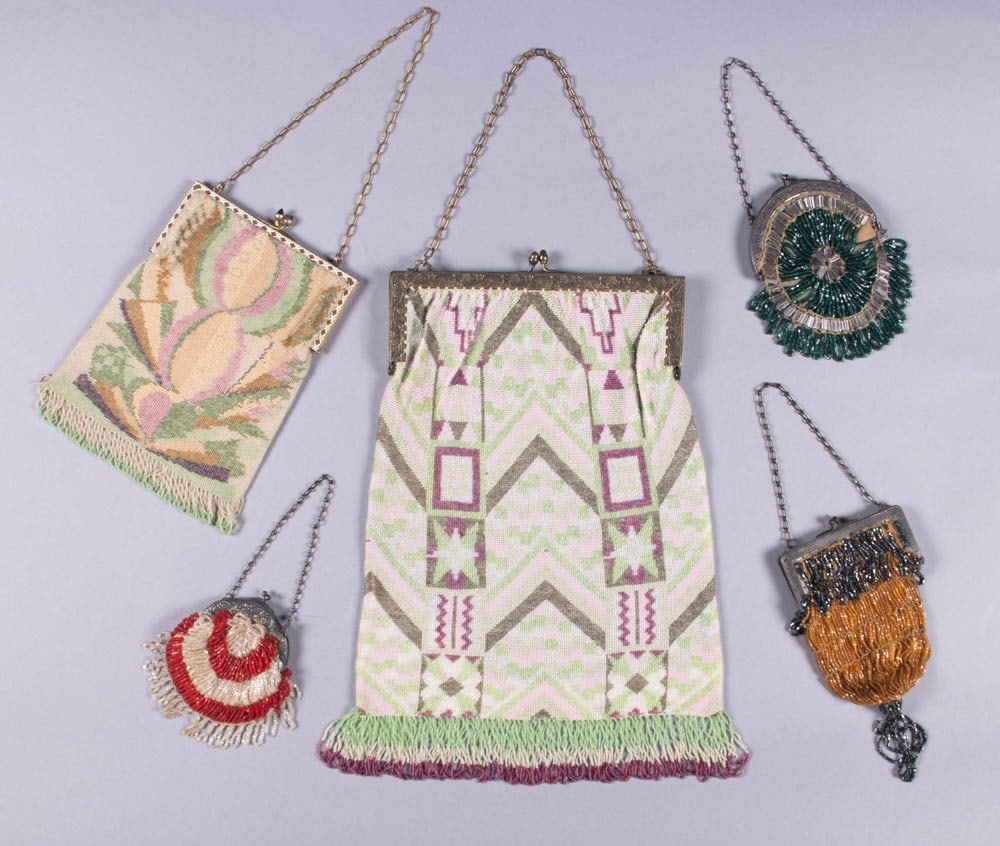 FIVE BEADED BAGS, 1910s-1920s: 2 woven beaded bags in geometric motifs in shades of pink, wine, green & tan, both w/ twisted fringe, early 1910s: 1 smaller w/ enamel frame, blue sugarloaf stone closures & moire silk lining; 1 w/ gr