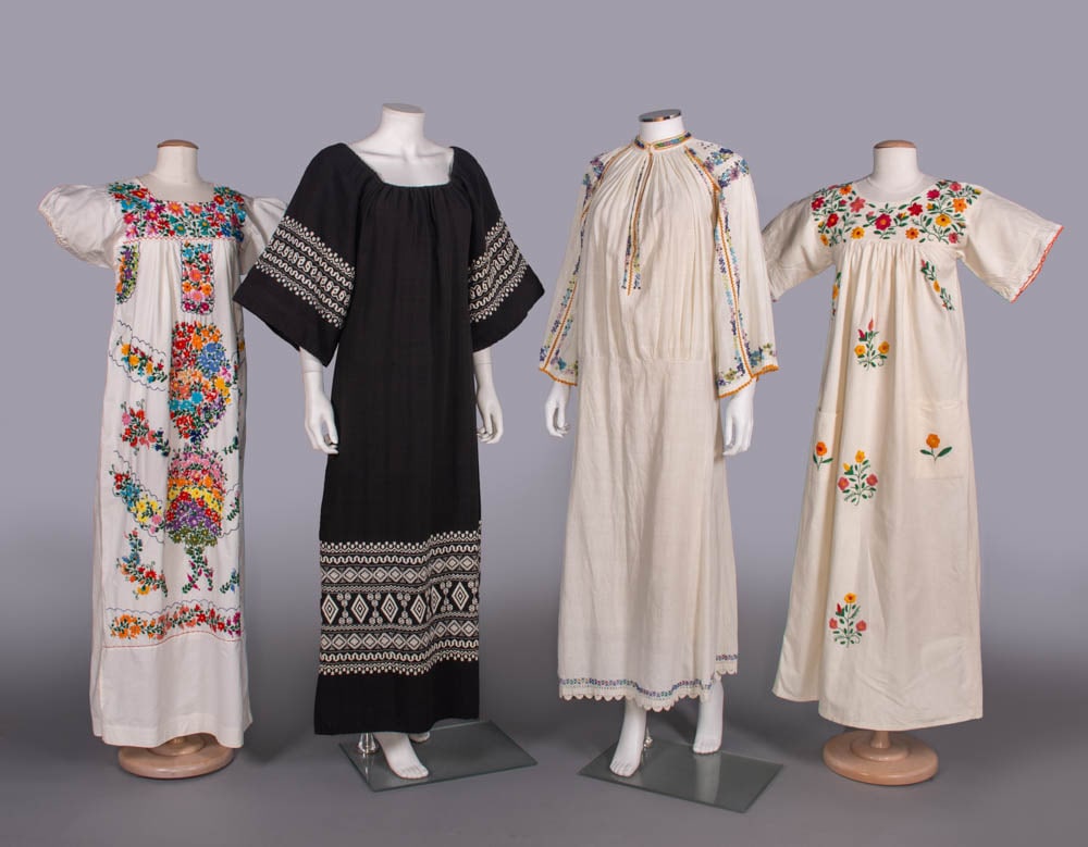 FOUR COTTON FOLK DRESSES, MEXICO & CENTRAL EUROPE, MID-LATE 20TH C: 1 white cotton Mexican dress embroidered w/ cotton multicolor flowers, B 36”, L 55”, (cuff elastic shot, light discoloration lower skirt, tiny light stains esp. sleeves); 1 black cotton w/