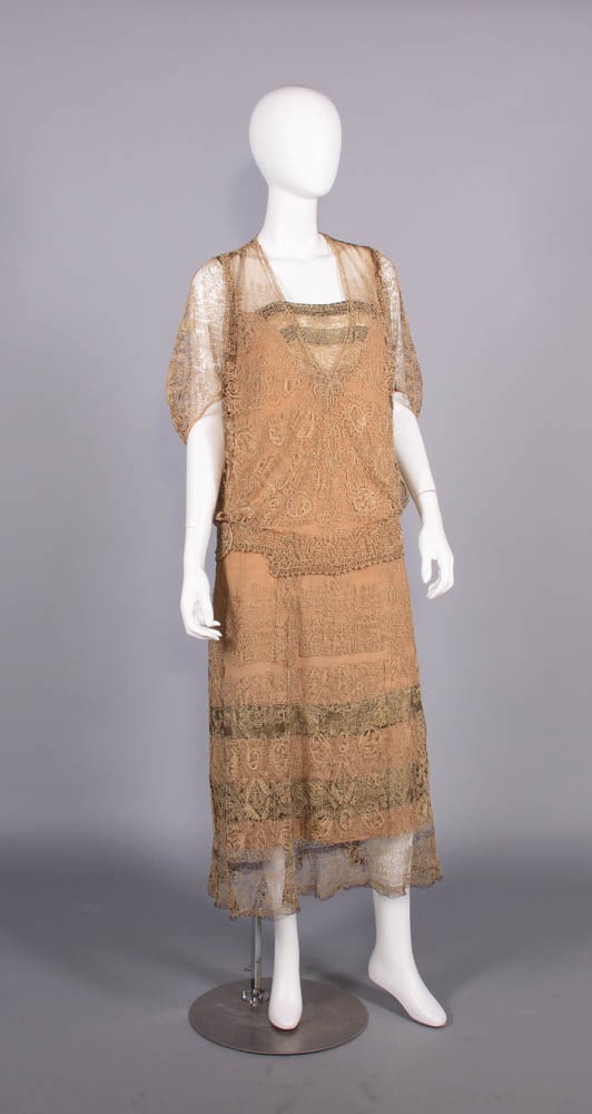 SILK & LAME’ DRESS WITH ELABORATE CORDED APPLIQUE’, c. 1923: Cafe au lait silk tulle afternoon dress w/ dense applied cord all over silk crepe w/ gold lame bands at CF B & over skirt, 1923, B 42”, W 40”, L 52”, (underarm discoloration, 1&rdquo