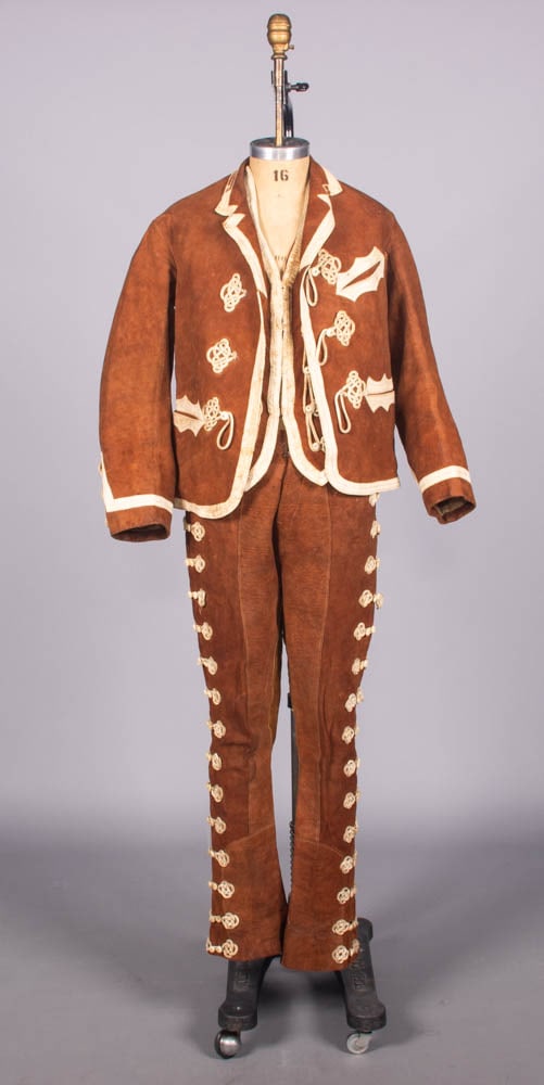 THREE PIECE DEERSKIN VAQUERO ENSEMBLE, INDIAN TERRITORY, 1890s: 3-pc deerskin riding ensemble w/ white leather trim & decorative leather frogging w/ bone buttons c/o coat, vest & trousers w/ bone & MOP button fly, suspender buttons, decorative frogging along SSs, 
