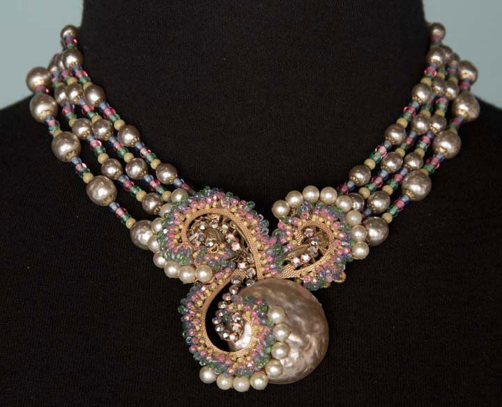 HASKELL BAROQUE PEARL NECKLACE, 1940-1950: Pink, green, blue & yellow beads, baroque pearls & rhinestones on large center cluster & on 4 beaded & pearl strands, Miriam Haskell stamped under clasp L 14", excellent. From Estate of fashion histor