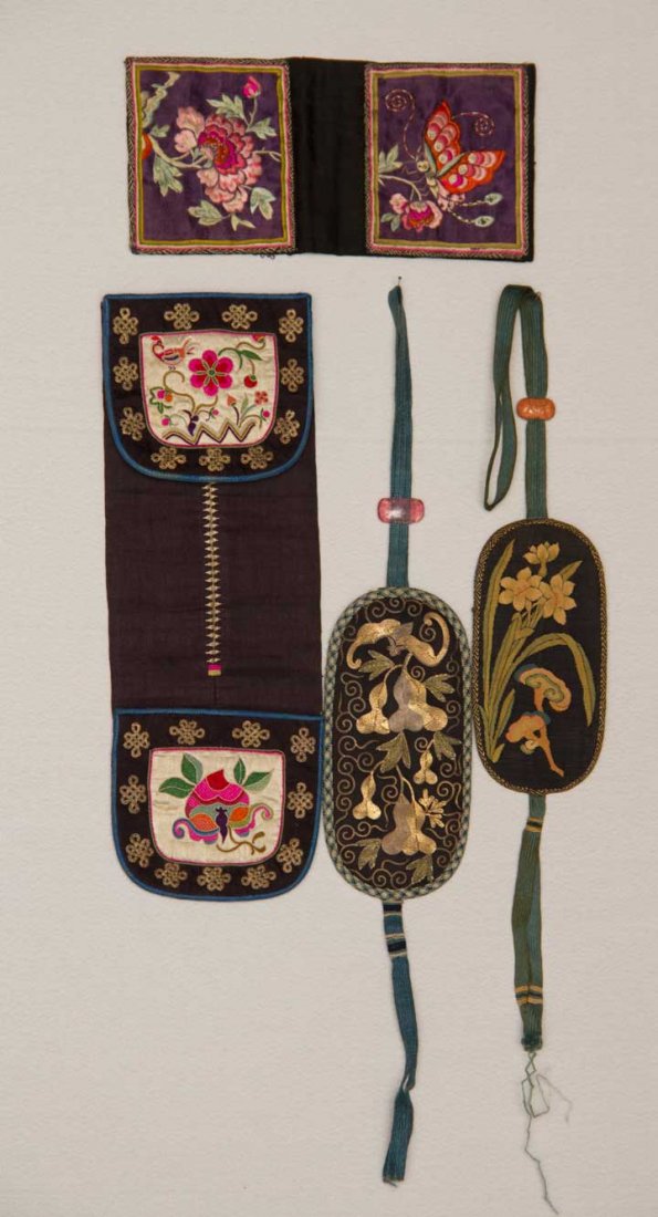 MONEY & SPECTACLE CASES, CHINA, 19TH-20TH C: 2 folding money cases, black silk w/ polychrome embroidery, 4" x 15" & 4" x 11"; 2 oval spectacle cases, both w/ woven cords having glass or carved beads: 1 w/ gold couched embroidery & 1 tapestry wov