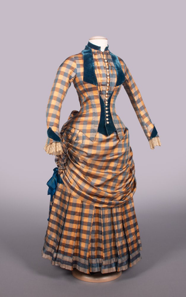 GINGHAM SILK TWILL DAY DRESS, 1889: 2-pc gingham striped silk twill in peach, brown & blue w/ blue silk velvet collar, faux reveres, cuff & faux waistcoat, CF MOP globe button closures, chemical lace cuffs, self & royal blue silk satin