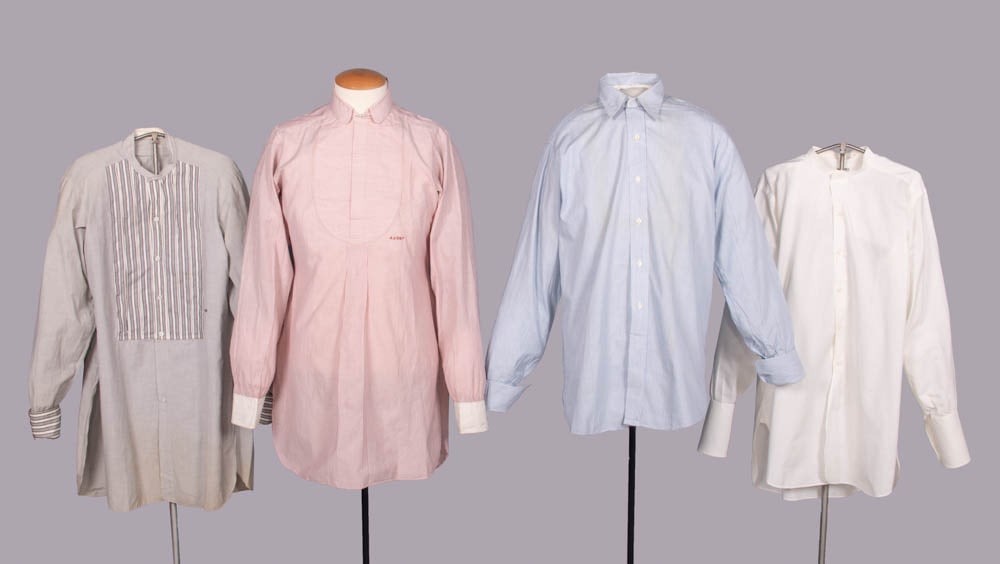 FOUR COTTON MANS SHIRTS, USA, 1910-1930s: 1 collarless grey chambray w/ striped cotton bib front & French cuffs, CH 42”, L 33”; 1 red & white striped cotton w/ detachable collar, CH 44”, L 35”, collar 15”; 1 blue