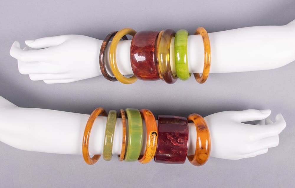 GENEROUS LOT OF VINTAGE BANGLES, MID 20TH C: 14 vintage bangles in shades of caramel, burgundy & green, Wd 0.125”-1.75”, circ 7.25”-8”, (most w/ light wear, minor scratching/scuffing, few w/ moderate wear/scuffing, few ti