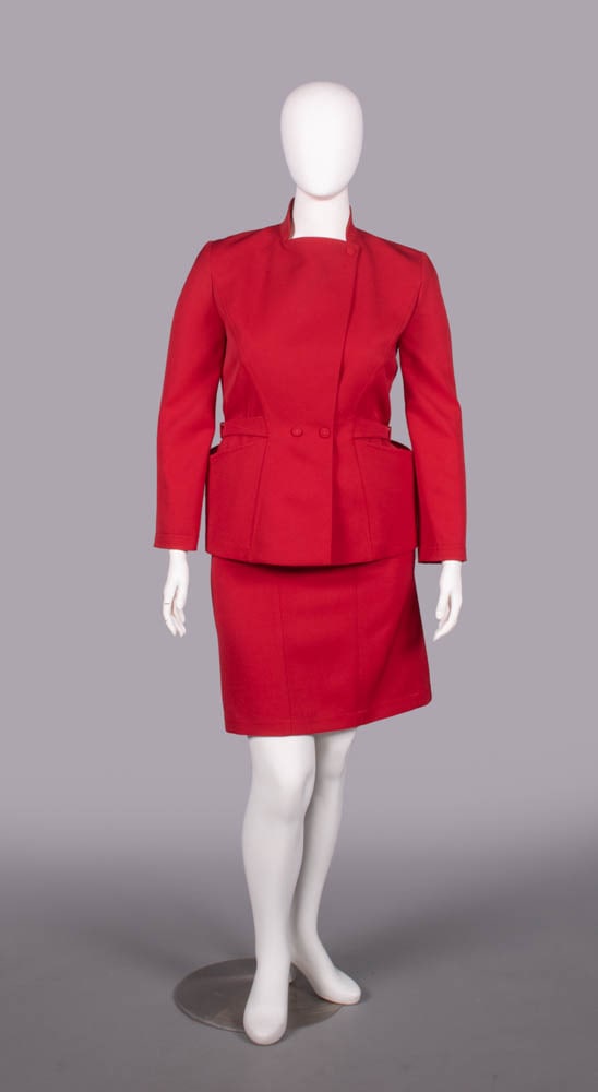 THIERRY MUGLER WOOL SKIRT SUIT, PARIS, c. 1990: 2-pc wool skirt suit c/o jacket w/ self-covered snap closures at throat & W of cross over front, W tabs w/ self-covered decorative buckles over Hs accentuating large open inset H pockets, matching ski