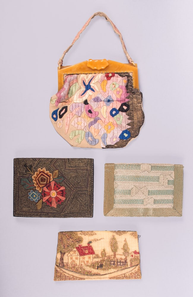 FOUR EMBROIDERED CLUTCHES OR PURSES, FRANCE, 1920-1940s: 1 Polish inspired silk floral embroidery on tan silk crepe purse w/ butterscotch early plastic frame, 9.5” x 9” + 5.5” handle, (few small stains/tiny holes, light wear, minor shatter