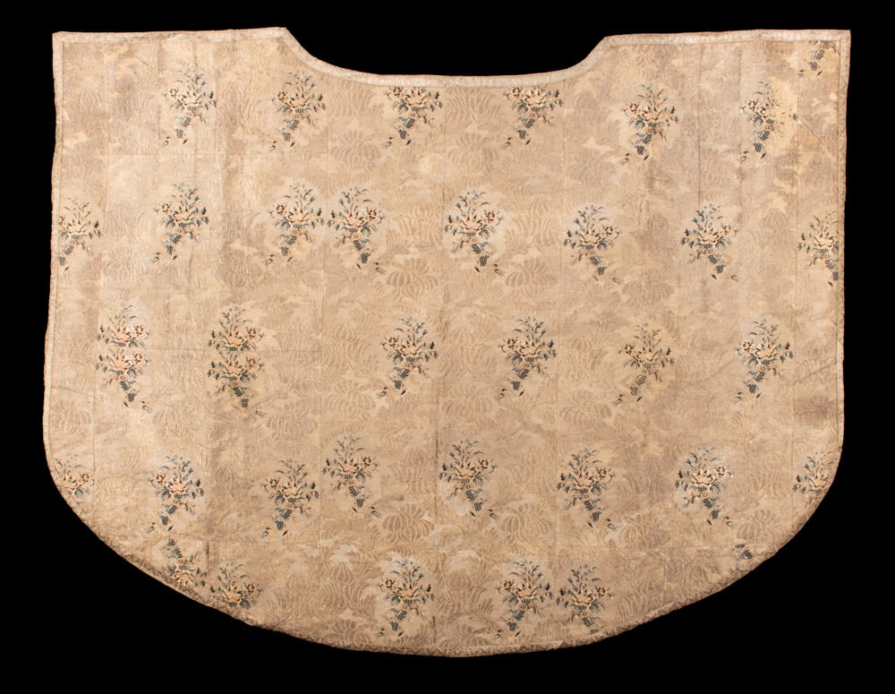 METALLIC BROCADE VESTMENT, 1840s: Metallic brocade vestment w/ floral weft face pattern in black, blue, pink & cream, silver metallic gallon edging, modern backing, possible Eastern Christian orthodox, 69” x 49”, (broad ta