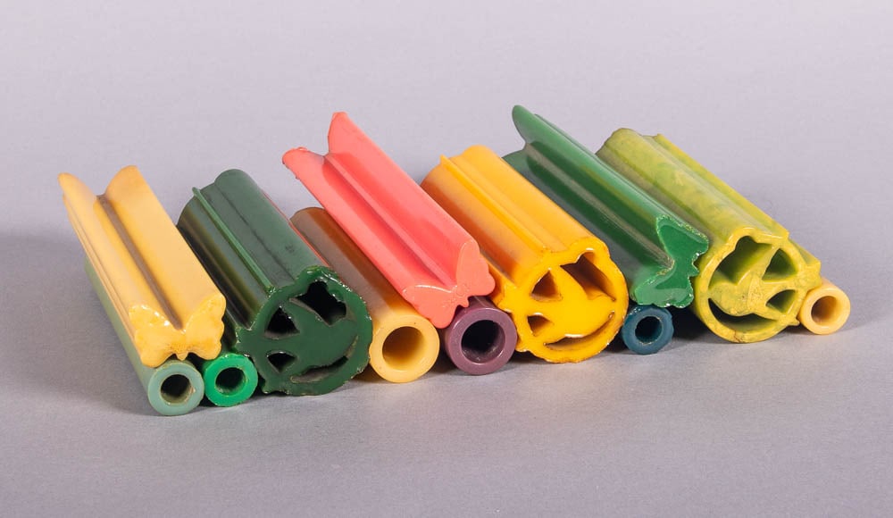 LARGE COLLECTION OF UNCUT BAKELITE OR CATALIN RODS, 1930-1950s: 12 catalin rods: 3 butterfly motif in hot pink, goldenrod & green, 1.5” x 7.75” each; 3 large swallow motifs in forest green, goldenrod & marbled lime, 2.25” x 6” each; 6 hollo