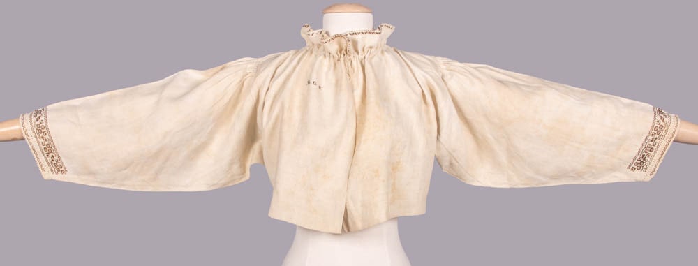 EMBROIDERED FOLK UNDERBODICE, NORTHERN EUROPE, EARLY 19th C: Embroidered linen underbodice w/ standing gathered collar on inserted cord, free front, cartridge pleated shaped sleeve w/ italian hemstitching to sleeve edge, cross stitch embroidery to collar & slee