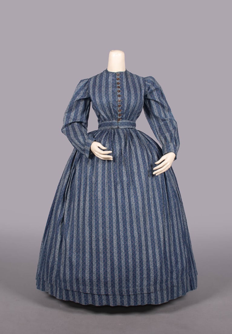 PRINTED COTTON DAY DRESS, LATE 1850s: Resist dyed & printed cotton calico day dress w/ tortoise shell CF button closure, cartridge pleated W, hand sewn, B 32", W 24", L 51", (some minor wear & fading esp. SLVS, 0.25" stain & missing closu