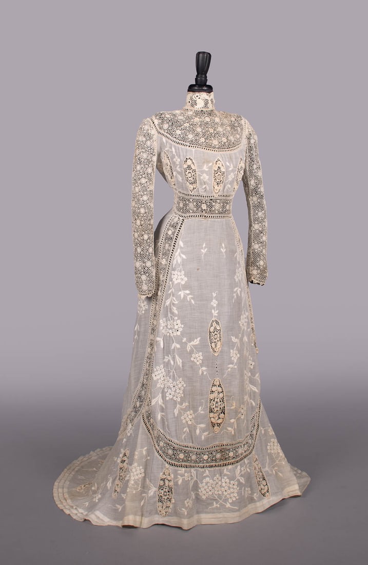 IRISH CROCHET & HAND EMBROIDERED LINGERIE GOWN, c. 1908: Trained cream cotton mull lingerie gown w/ Irish crochet collar, yoke, long sleeves & inset panels interspersed w/ Philippine embroidered cotton mull, CB crochet ball button & loop closures, B 36", W