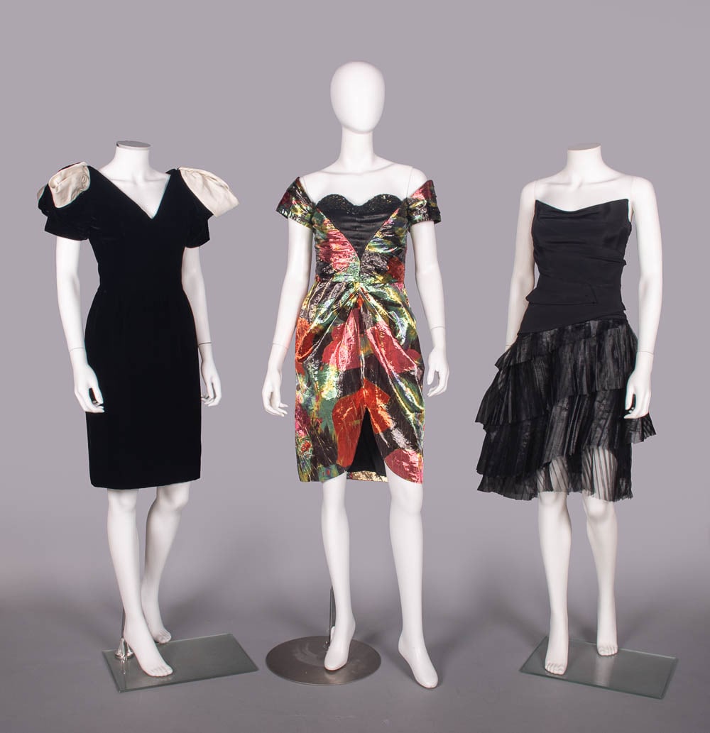 THREE SILK OR LAME PARTY DRESSES, USA, 1980s & 2000s: 1 black silk velvet dress w/ dramatic white twill silk sleeve accents, label "Victor Costa", B 35", W 26", L 38", (few minor crush spots) excellent; 1 multicolor printed gold lame dress w/ off-the-sho
