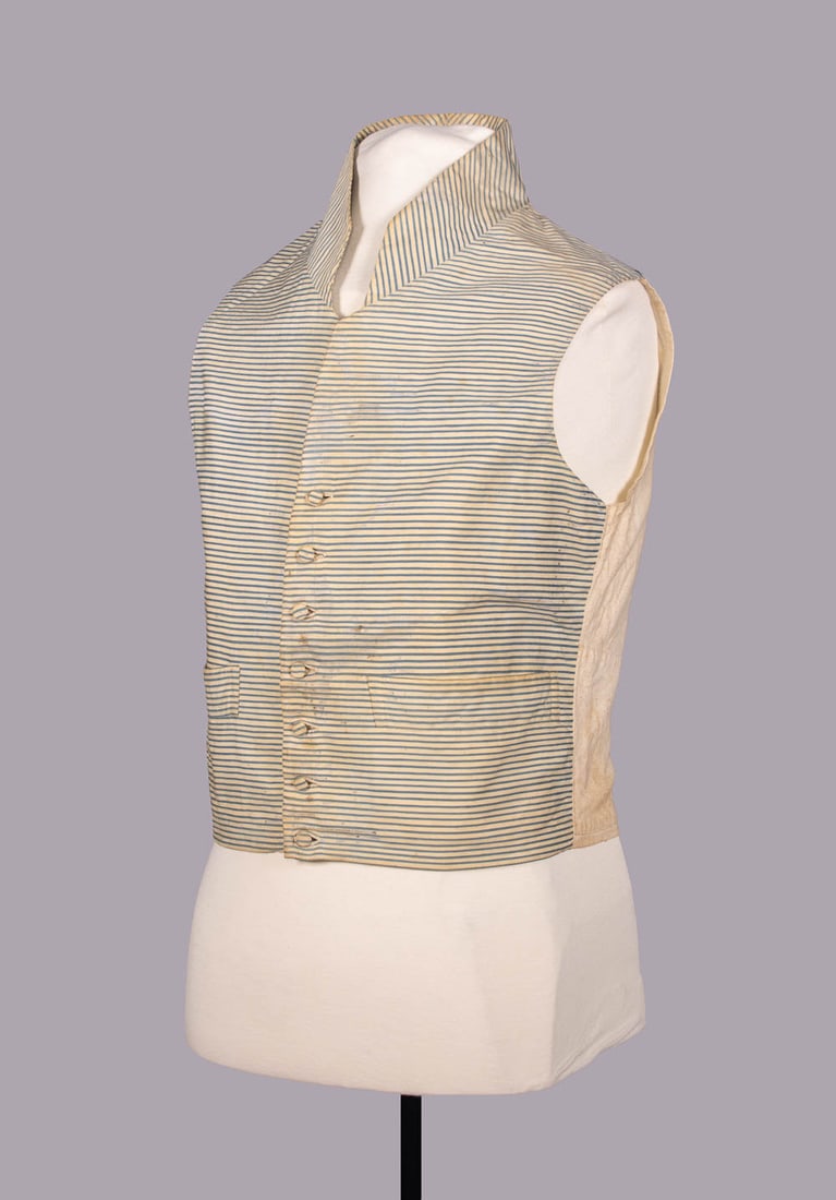 GENTS STRIPED SILK WAISTCOAT, c. 1795-1804: Blue & cream horizontal striped silk waistcoat w/ set in pockets, self-covered buttons, cotton & linen lining, standing attached collar, hand-stitched, c. 1795-1804, CH 38", L 19", (broad light discol