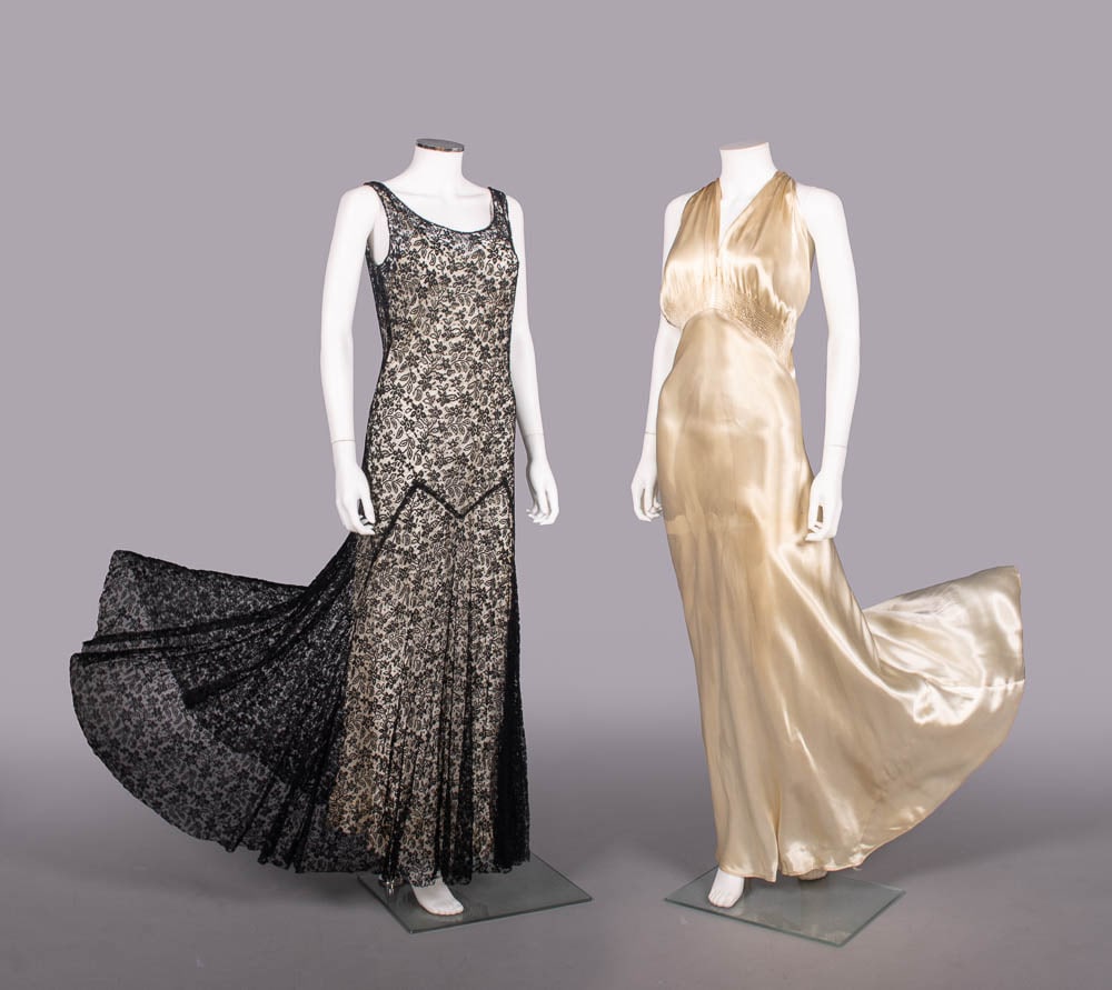 TWO LACE OR SATIN EVENING GOWNS, 1930-1935: 1 sleeveless black mm lace evening dress w/ scoop neckline into plunging V back, drop W w/ floor length skirt, c.1930, B 32"-34", W 24"-26", L 58", (slip N/I, 3" tear LF hem, several tiny-1.5” s