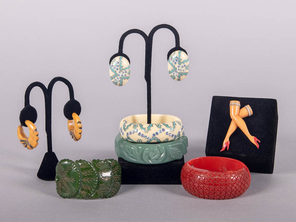 BAKELITE & COMPOSITION JEWELRY, 1930-1960s: 1 pair of carved hoop earrings, 1.25" x 1.25", (minor residue, minor tarnish to clip-ons); 1 carved green clamper bracelet, circ 6.5", Wd 1", (light scuffing/scratching, minor residue); 3-pc cream & t