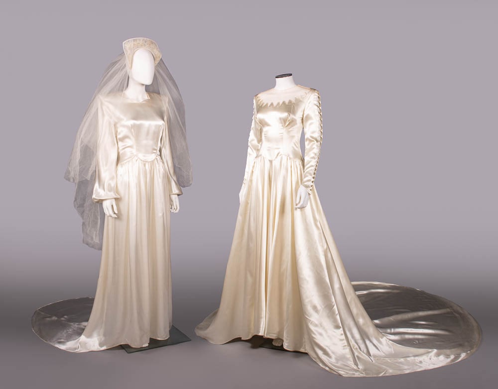 TWO SATIN WEDDING GOWNS, 1940-1950: 1 white silk blend satin wedding gown w/stong SH, long bishop sleeves, piped faux peplum W & chapel length train, c. 1950, B 34", W 28", L 59"-84", (marks/scuffs to 3”, cuff elastics dried, pull
