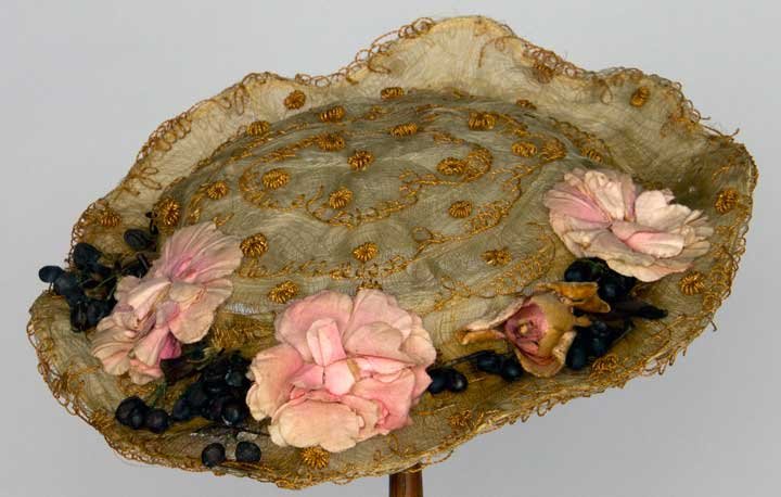 EMBROIDERED HORSEHAIR HAT, c. 1912: Woven horsehair on wire foundation, embroidered w/ fanciful straw elements & trimmed w/ pink cloth flowers, wedge band under back to tilt hat forward, (ivory chiffon lining damaged, some breaks in str