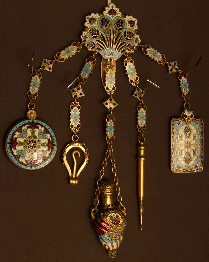 ENAMEL CHATELAINE, EUROPE, LATE 19TH C: Gold metal w/ blue, red, & white enamel, center piece w/ 5 chain drops consisting of 1 pencil, 1 writing tablet, 1 button hook, 1 perfume vial, 1 mirror case, (mirror & enamel pencil case missing) ver