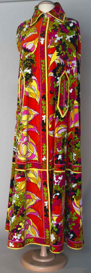 PUCCI VELVET BEACH CAPE, 1970s: Velvet on outside, terry cloth inside, orange, red, green, yellow, black & brown stylized floral print, 2 slits for arms, label "Emilio Pucci Florence Italy", B 34", L 56", excellent. Provenance: Mme.