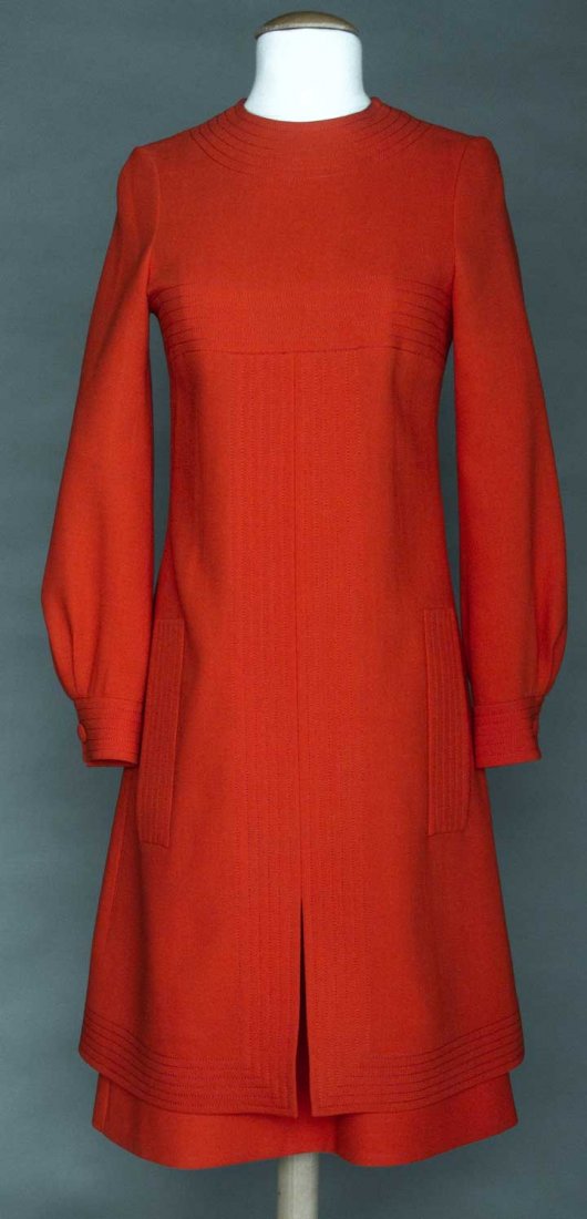PIERRE CARDIN WOOL DAY DRESS, 1970s: Tomato red, long sleeves, channel quilted details throughout, faux pocket flaps, CF slit, back w/ curved overpanel & CB bow, label "Pierre Cardin Boutique Paris", B 34", L 40", excellent. Provenance: 