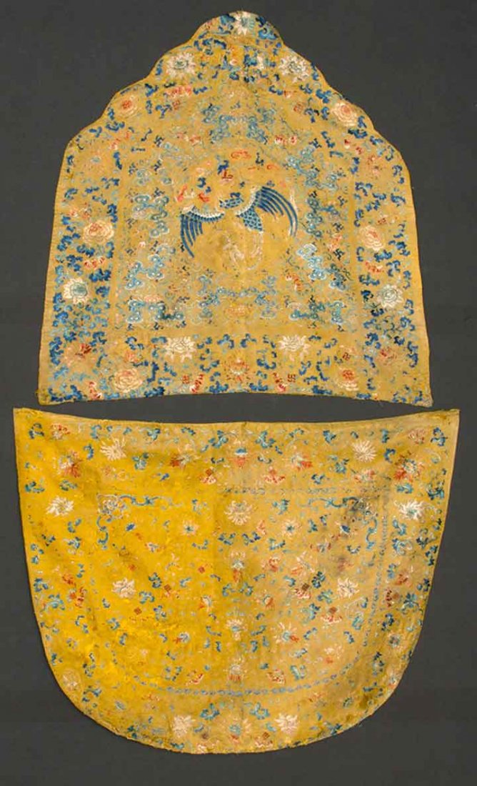 TWO IMPERIAL CHAIR COVERS, CHINA, 19TH C: Both on yellow silk & embroidered in reds, blues & white, golden yellow silk twill backings: 1 shield shape, center rondel w/ phoenix surrounded by clouds & bats w/ deep floral border, 24.5" x 23.25";