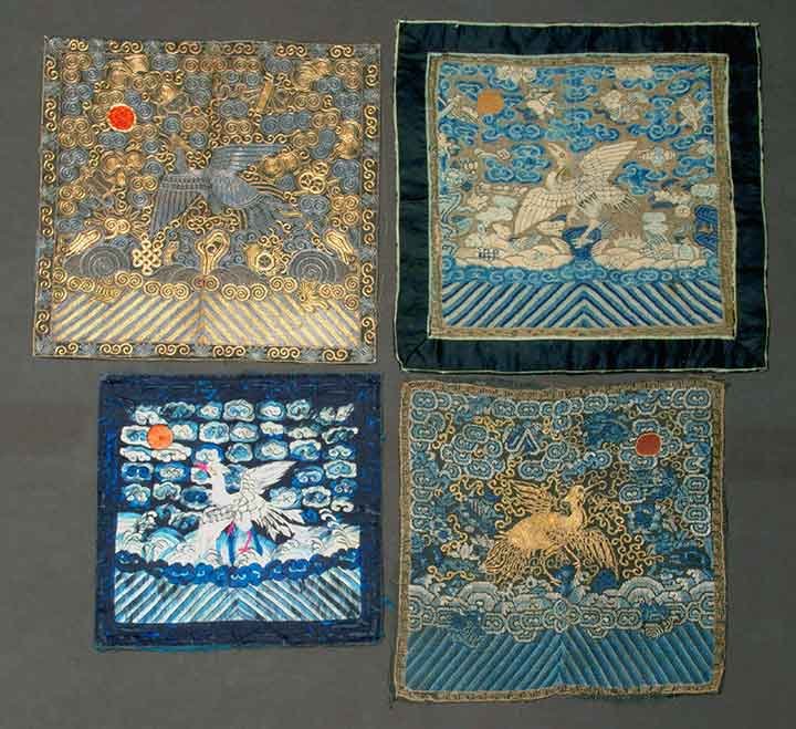 FOUR RANK BADGES, CHINA, 19TH C: All w/ storks amongst clouds & moon w/ waves below: 1 kesi woven in shades of blue, white & orange, 13" x 12.5", (faded); 1 silk embroidered in shades of blue, white & orange , 9.75" x 9.5", (minor si