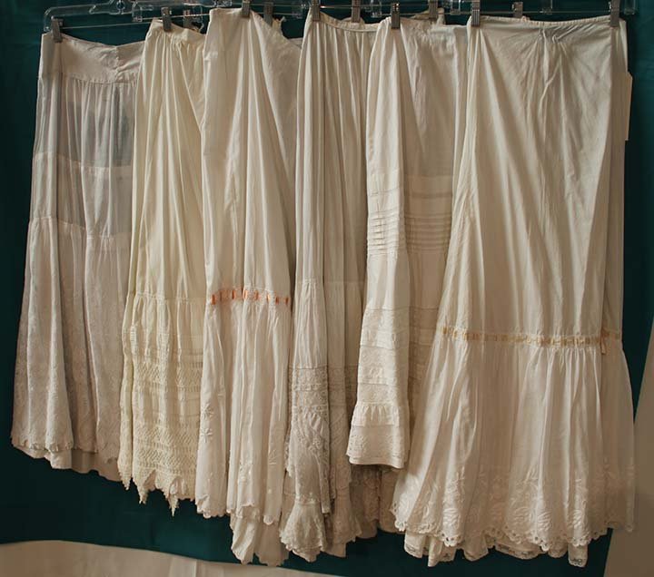 SIX WHITE PETTICOATS, 1890-1915: All fine cotton w/ embroidery or lace, deep hem flounces, fair-excellent.