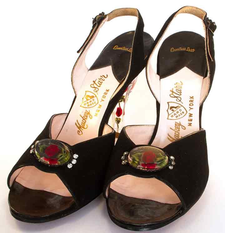 PAIR LUCITE & SUEDE SHOES, 1950s: Deadstock, black suede slingback evening sandals, clear lucite heel & lucite oval on vamp both w/ red roses inside, soles stamped "Mackey Starr Hand Made New York", L 9", W 3", Heel Ht 4", excellent.