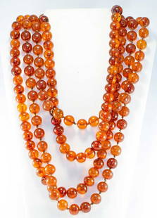 PAIR AMBER NECKLACES, EARLY 20TH C: Both Baltic clear caramel amber strung on cord, 46" each, some beads w/ interior crackles, excellent; t/w 4 strands small green quartz beads strung on cotton floss, totalling 50"; 1 European paste pen