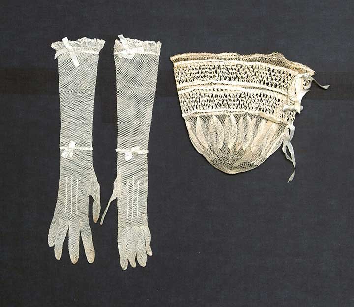 RETICULE & GLOVE SET, ENGLAND, c. 1820: Both knotted linen thread & w/ original silk ribbon drawstrings: 1 reticule worked in 2 thicknesses of linen thread, 8.5" x 9", (1 stain); 1 pair elbow-length gloves, L 15", (stains on fingertips); t/