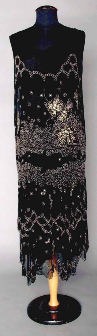 CRYSTAL BEADED DRESS, EARLY 1920s: Black silk chiffon, sleeveless, double layer hem decorated w/ crystal beads, silver metal beads, rhinestones & sequins in abstract pattern, (minor bead loss & L-shaped tear at left shoulder) very good